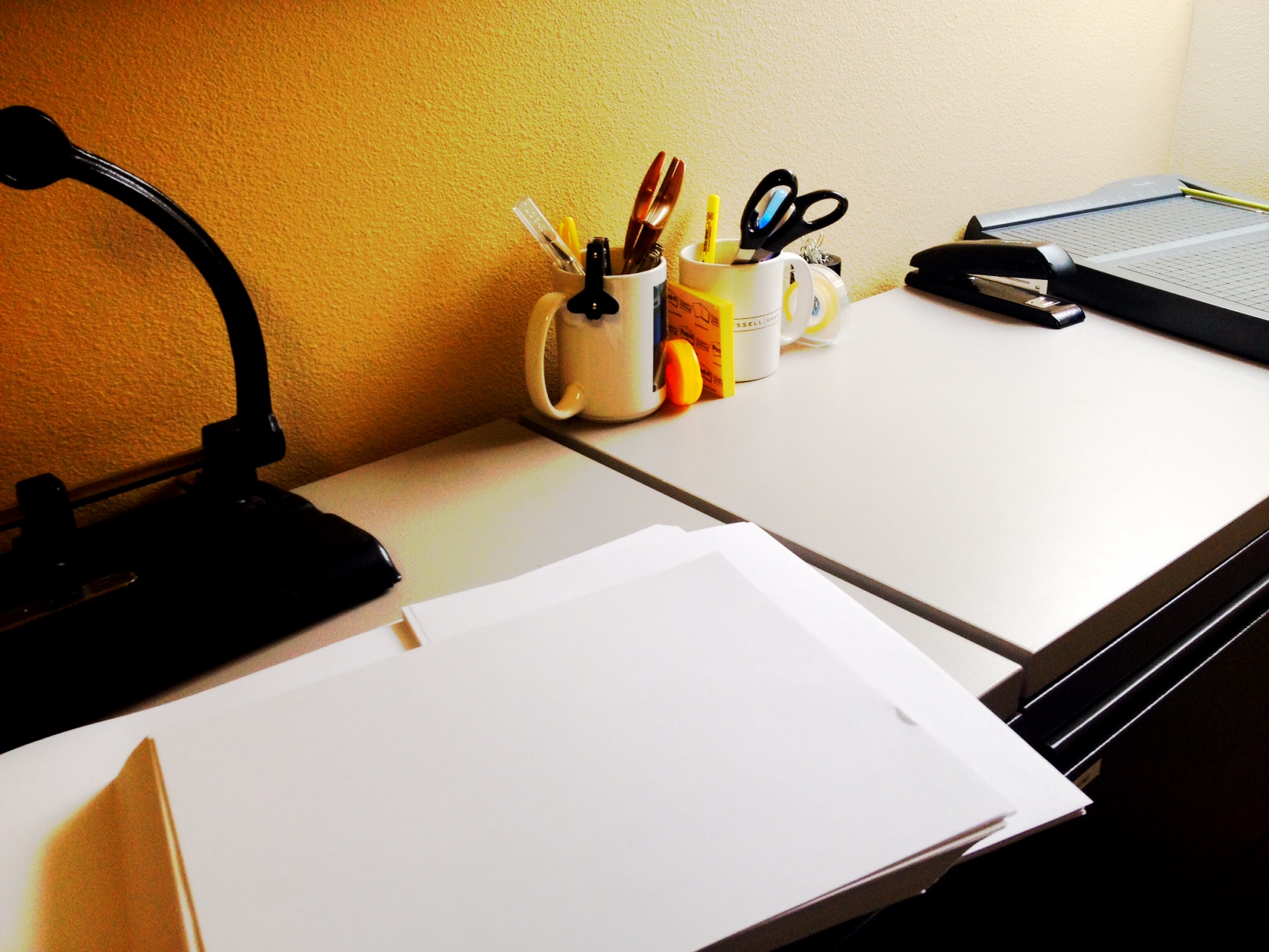 Photo of office workspace with paper, pens, etc.